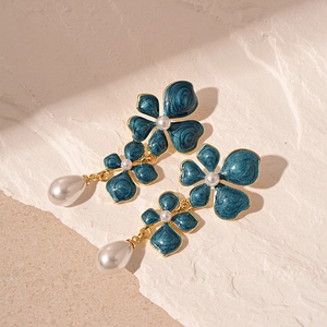 Detailed macro view of vintage flower earrings with blue enamel and pearl water drops