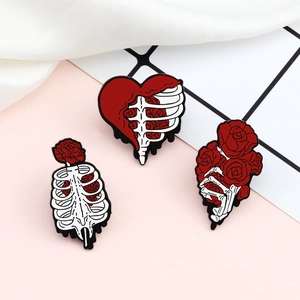 Three enamel pins featuring white skeletons and red roses on pink grid background
