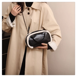 Détail du sac bandoulière en cuir noir avec bordure en fausse fourrure blanche