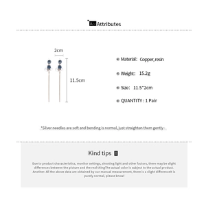 Detailed specs of long tassel earrings featuring blue resin beads and brass chain details