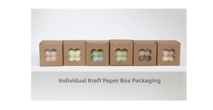 Detail of multi-colored scented candles in kraft boxes with clover window cutouts