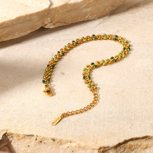 Detail of 18K gold stainless steel bracelet with green enamel olive leaf charms and clasp
