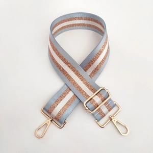 Detail of adjustable blue and gold striped handbag strap with light gold metal lobster clasp