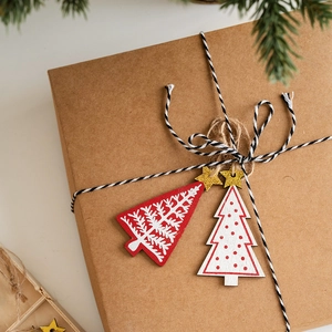 Nordic wooden Christmas tree hanging tags with glitter stars on kraft paper gift box