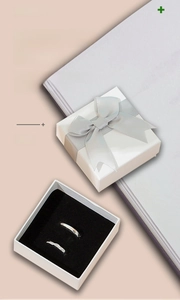 Detailed view of white jewelry gift box with silver bow and black velvet lining