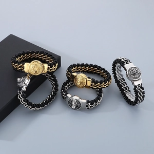 Detail of woven black leather bracelets with silver and gold lion and wolf heads