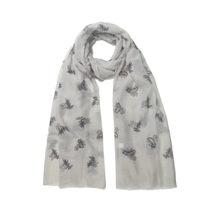 Detailed view of light gray scarf with metallic bee prints and frayed tassel edges