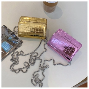Detail of crocodile embossed mini square bags in gold and pink with metal chains