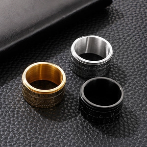 Close-up of three rotatable men's steel rings in gold, silver, and black finishes