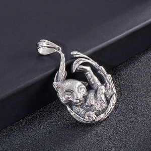 Macro detail of silver curled cat pendant with intricate feather leaf textures