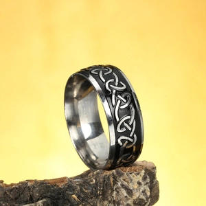 Nordic Celtic knot stainless steel ring in black and silver on a textured rock base