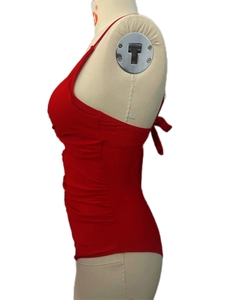 Side view of red ruched one-piece swimsuit on mannequin showing slimming fabric texture