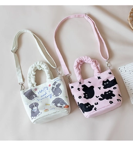 Detail of cute canvas bucket bags with cat and dog patterns in white and pink colors