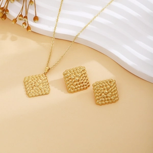 Detail of gold metal jewelry set with square woven texture necklace and earrings