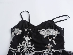 Nahaufnahme der schwarzen Paillettenstickerei und verstellbaren Träger am eleganten Kleid