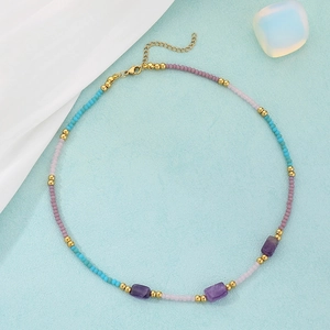 Detail of beaded necklace with purple stones, colorful beads, and gold lobster clasp