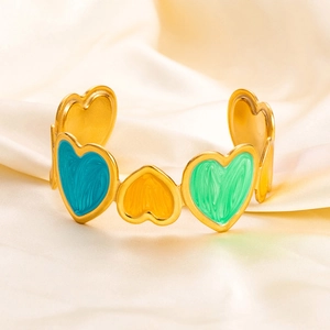 Detailed macro view of multi-colored enamel hearts on a 18K gold plated stainless steel bangle