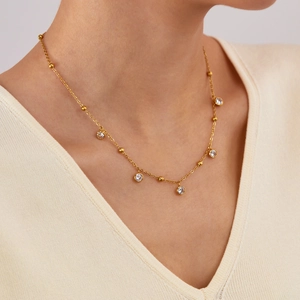 Minimalist gold plated stainless steel necklace with small beads and zircon pendants on model