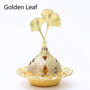 Detail view of golden leaf decorative lid and hollow carvings on metal incense burner