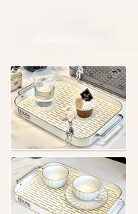 Detail of white rectangular draining tray with silver bunny decor and metal handles