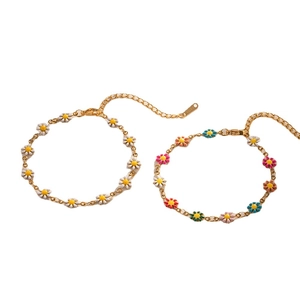 Bohemian style gold daisy chain necklace with colorful enamel flowers on white background