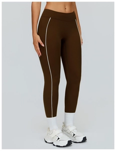Dettaglio dei leggings yoga marroni a vita alta con strisce bianche e tessuto elastico