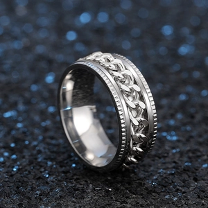 Detail of a rotating silver stainless steel spinner ring with a Cuban chain pattern texture