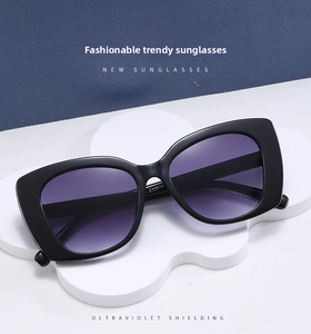 Detail of black cat-eye sunglasses with purple gradient lenses on a cloud stand
