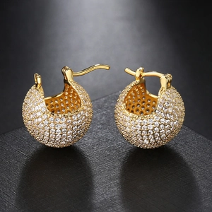Macro shot of gold-plated hinged huggie earrings with pave-set sparkling zircons