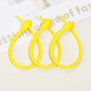 Three bright yellow silicone cable ties in a linked loop showing flexible material texture
