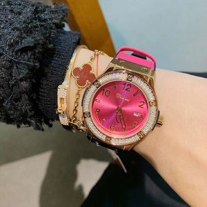 Rose gold quartz watch with pink silicone strap and crystal bezel on wrist