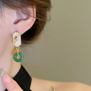 Detail of New Chinese style drop earrings with green jade ring and gold enamel inlay