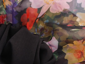 Detailed macro view of black lining fabric and colorful floral organza mesh material