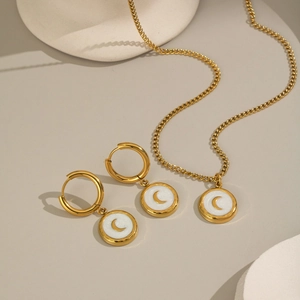 Schmuckset aus Gold mit Mond-Print-Ohrringen und Halskette sowie weißer Muschel-Einlage
