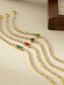 Detailed close-up of colorful crystal tennis bracelets with gold plating on wood