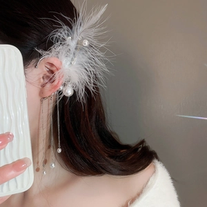 Detail of feather ear cuff with long metallic fringe and white pearls worn by a model