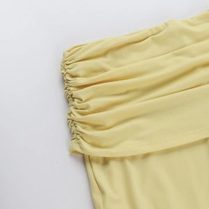 Dettaglio macro dell'arricciatura laterale con coulisse sul set yoga giallo acceso