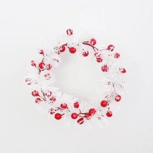 Christmas wreath featuring red berries and snowy white pine needles on a plain background