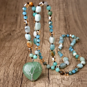 Macro shot of green heart jade pendant with silver tree of life wire wrapping