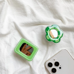 Detail view of green checkerboard flower and square folding mirror phone sockets