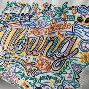 Close-up of colorful graffiti embroidery and Young Life journey text on canvas bag