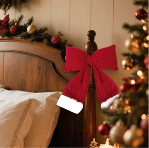 Close-up of red velvet Christmas bow with white faux fur trim on a wooden bedpost