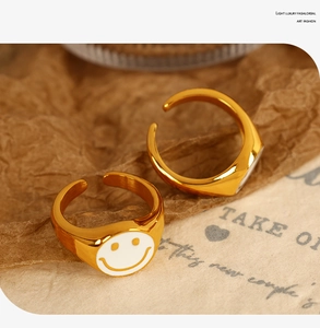 Detail shot of vintage 18K gold plated smiling face ring with white enamel drip finish