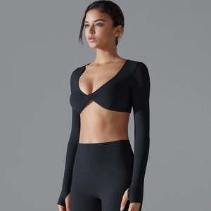 Dettaglio top yoga nero con fori per i pollici e design a incrocio con scollo a V