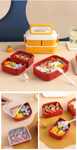 Detailed view of yellow and red double-layer lunch box with Peter Rabbit theme and utensils