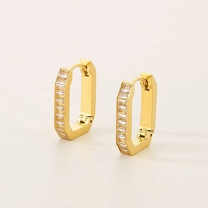 Macro shot of gold-plated geometric U-shaped earrings with inlaid rectangular zircons