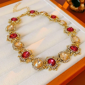 Macro view of vintage gold necklace with red and amber stones in a jewelry box