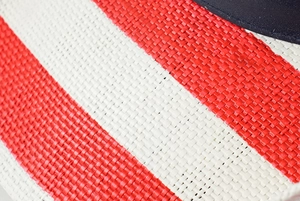 Gros plan sur la texture tissée à rayures rouges et blanches d'un chapeau de paille