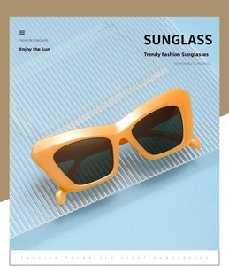 Macro shot of bright orange thick frame sunglasses with dark gray polarized lenses