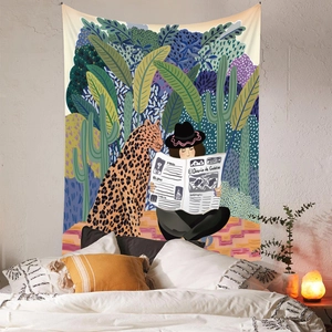 Detail of bohemian jungle tapestry featuring a leopard and reader in a cozy bedroom